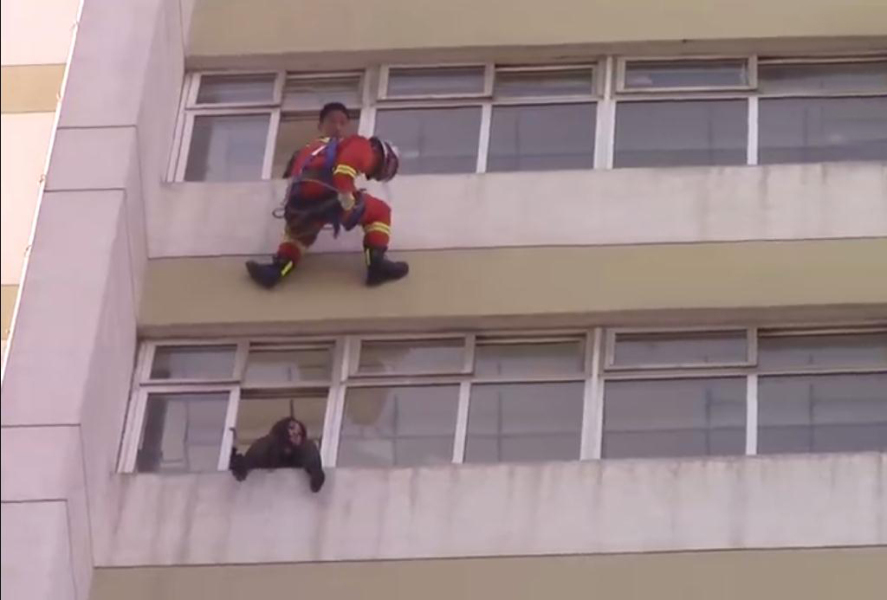 经过对现场形势的研判，消防员决定采用10楼悬垂速降，迅速将被困人员推进窗台内的救援方案。 