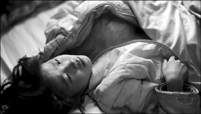 由于"巨瘤"压在胸前疼痛难忍,央姆独自躺在床上无声流泪.