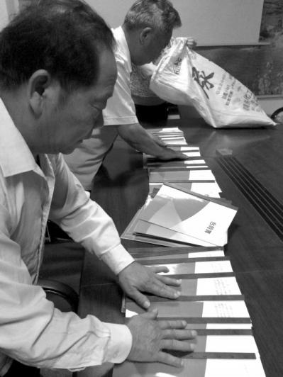 武金成向记者展示业务员与公司签订的合同。